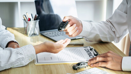 Salesman agent sending a key to customer after the good deal agreement, successful car loan insurance contract buying or selling new vehicle
