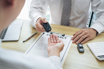 Salesman agent sending a key to customer after the good deal agreement, successful car loan insurance contract buying or selling new vehicle