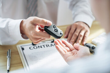 Salesman agent sending a key to customer after the good deal agreement, successful car loan insurance contract buying or selling new vehicle