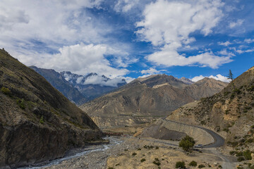 Winding road through the Kali Gandaki Valley, Mustang, Nepal. Adventure and trekking landscape. Ideal for travel, nature, transportation, and outdoor themes.