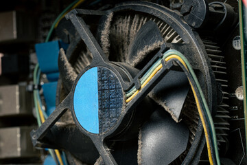 Dusty computer cooling fan and motherboard close up, dirty PC hardware component in need of cleaning and maintenance
