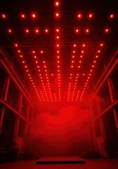 Empty music stage bathed in intense red light and thick smoke, with a ceiling array of spotlights