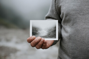 Old man hand photograph glacier memory misty outdoor Holding photograph of vanished glacier