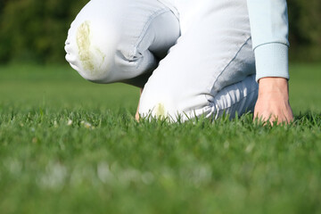 A person falling on green grass wearing white jeans, low angle from below. Outdoor accident, grass...