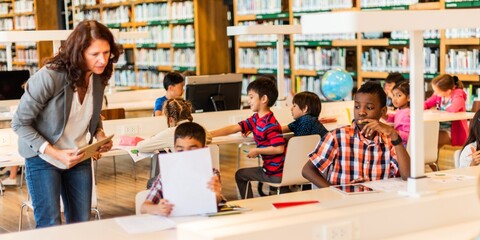 A diverse group of children in a library classroom, with a female teacher assisting. Diverse kids engaged in learning activities, surrounded by books. Elementary school children in library.
