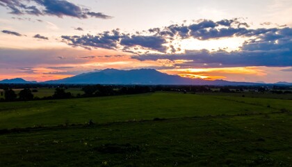 Landscape view of a mountain with a cloudy sky at sunset