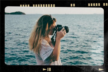 Woman with camera shooting on the beach
