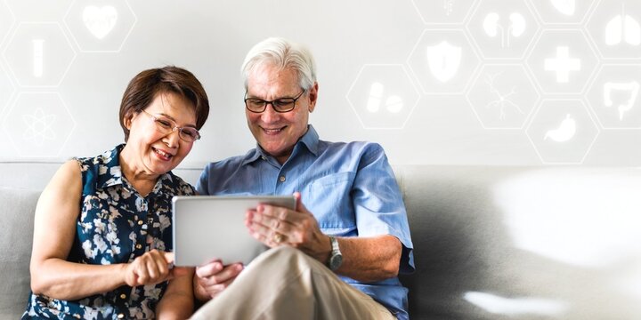 Senior couple using a digital device in a living room