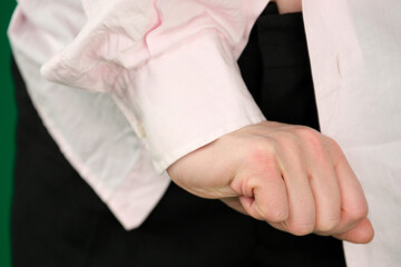Collection of closeup hand movements of young European woman in pink shirt on green chroma key background showing different gestures open palms folded hands and expressive poses with copy space.