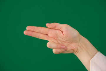 Collection of closeup hand movements of young European woman in pink shirt on green chroma key background showing different gestures open palms folded hands and expressive poses with copy space.