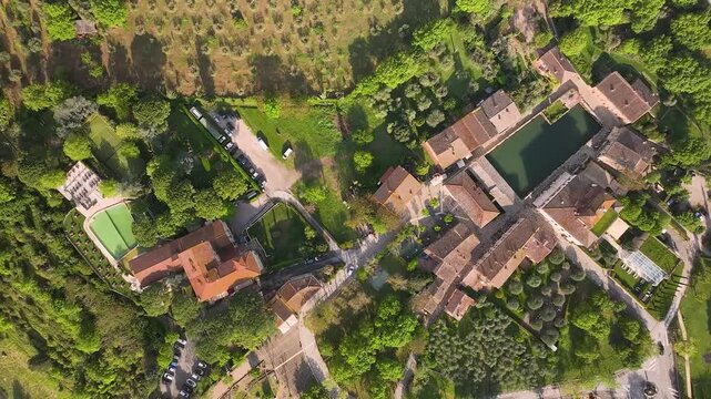 Aerial view of the ancient thermal pool in Bagno Vignoni, surrounded by buildings and lush greenery, a Tuscan haven of relaxation, Bagno Vignoni, Tuscany, Italy.