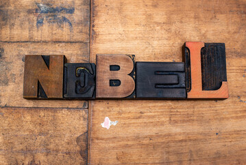 Das Wort Nebel, aus alten Holzbuchstaben ausgelegt. Der Untergrund ist Altholz. Starke Gebrauchsspuren sind zu erkennen