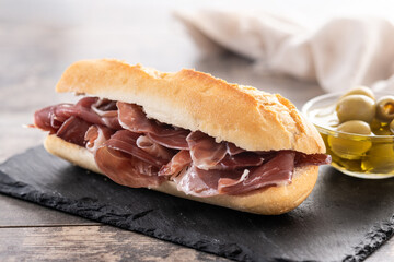 Traditional Spanish Serrano Ham Sandwich on wooden table
