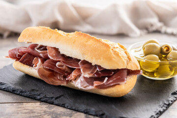Traditional Spanish Serrano Ham Sandwich on wooden table