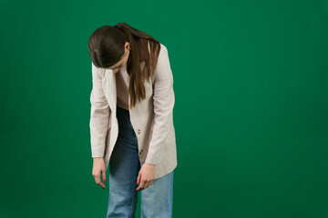 Professional photo collection of young European woman in light blazer with hair tied in ponytail and blue jeans on green chroma key background expressing different emotions and gestures perfect for ad