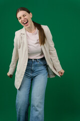 Professional photo collection of young European woman in light blazer with hair tied in ponytail and blue jeans on green chroma key background expressing different emotions and gestures perfect for ad