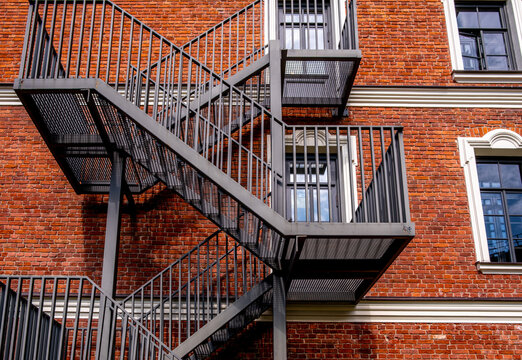 A fire escape ladder on the wall of a brick building in close-up.