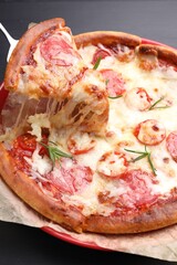 Taking piece of delicious pizza with cheese, salami and tomatoes at grey table, closeup