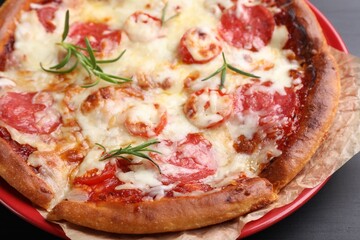 Delicious pizza with cheese and salami on black wooden table, closeup