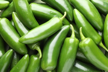 Many green jalapeno peppers as background, closeup