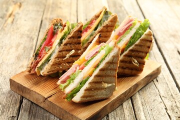 Tasty sandwiches with different fillings on wooden table, closeup