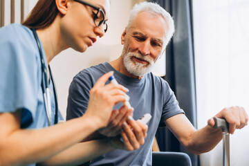 Female nurse, caregiver helping elderly man testing blood sugar. Doctor lancing finger male patient
