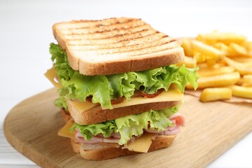 Tasty sandwich served with french fries on white table, closeup