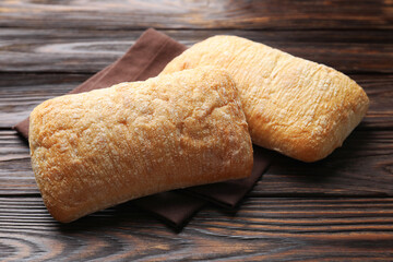 Freshly baked ciabattas on wooden table, closeup