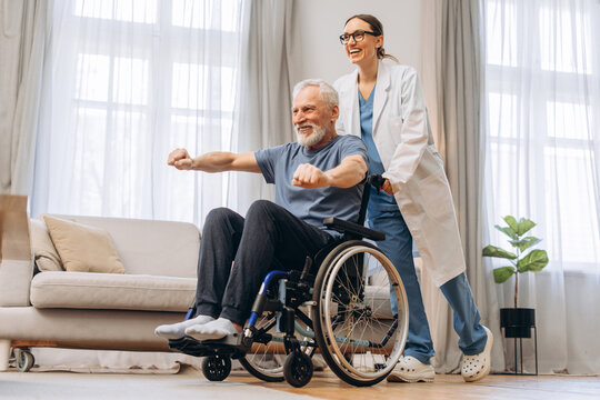 Elderly man doing physiotherapy exercises with caregiver at home - Powered by Adobe