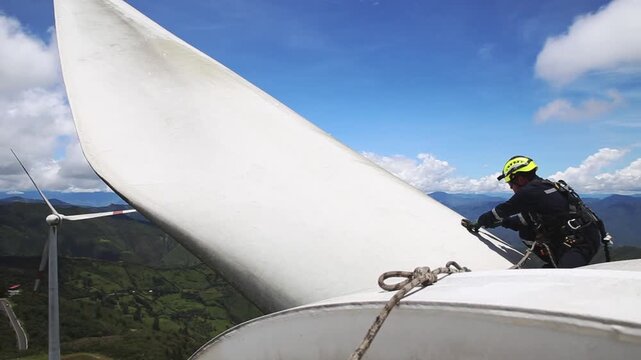 Worker cleans wind turbine blade in Loja, Ecuador, ensuring safety