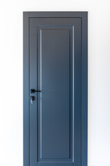 Blue interior door with key in lock on white wall. Minimal entry.