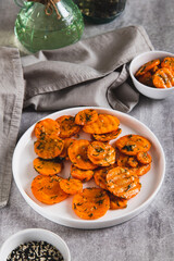 Fried carrots in spices and garlic on a plate on the table vertical view