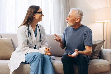 Obraz premium Professional doctor, female nurse consulting senior man during home visit