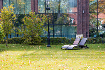 Banner. Two sun loungers on a green lawn in the hotel courtyard. The concept of rest, relaxation,...
