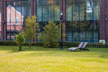 Banner. Two sun loungers on a green lawn in the hotel courtyard. The concept of rest, relaxation,...