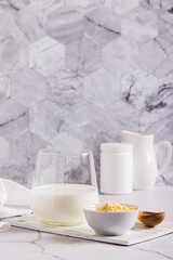 Colostrum powder in a bowl and a drink in a glass on a table vertical view
