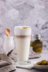 Latte with pickles in a glass and pickles in a bowl on the table vertical view