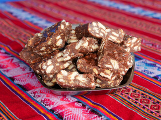 Close-up of blocks of chocolate brownie and biscuit sweets stacked on top of each other on a plate