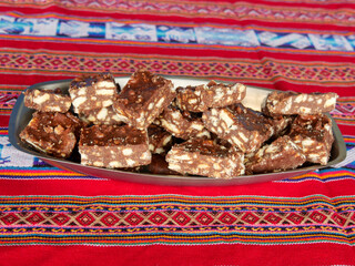 Close-up of blocks of chocolate brownie and biscuit sweets stacked on top of each other on a plate