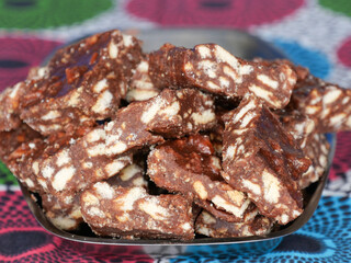 Close-up of blocks of chocolate brownie and biscuit sweets stacked on top of each other on a plate