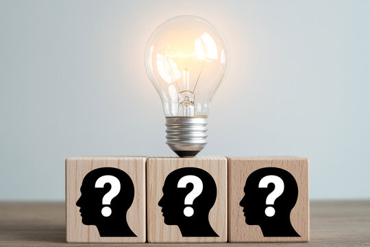 Idea generation problem solving concept with lightbulb and question mark head on wooden blocks for business