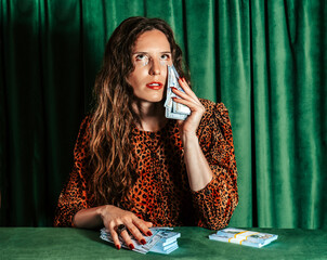 Humorous portrait mid adult holding money against face with velvet background