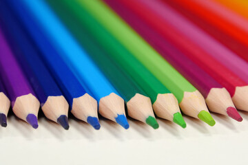 Naklejka premium New wooden colored pencils of rainbow colors, perfectly sharpened, lie on table