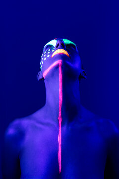 Artistic female portrait with body paint and uv light in studio