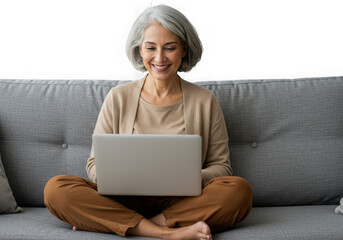 Smiling woman with gray hair using a laptop on a couch isolated on transparent background