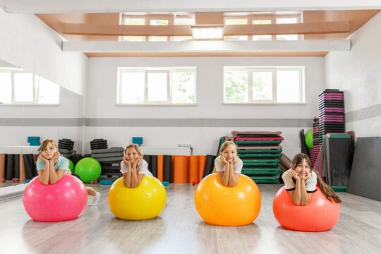 Happy kids resting on colorful fitness balls