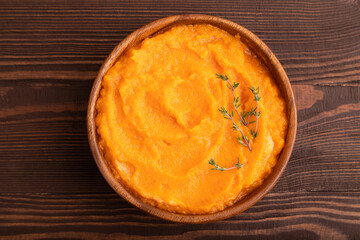 Sweet potato porridge in wooden bowl on wooden background. Diet, healthy eating. top view, close up