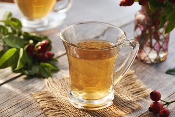 A cup of rose hip tea on a wooden table