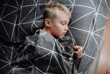 A handsome blond boy is lying in bed