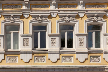 Historic building facade with four windows and stucco ornament